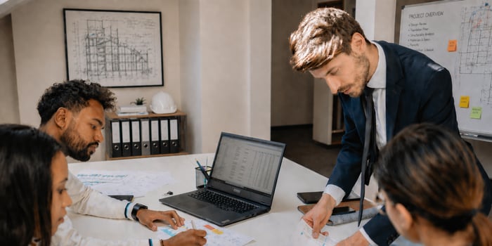 Construction preconstruction team reviewing project plans, data, and documentation in a collaborative estimating workflow session.